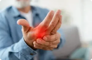 Person experiencing hand pain with red inflamed area, representing preventive healthcare and wellness management