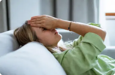 a women laying on sofa fatigued due to thyroid disorder seeking primary healthcare service