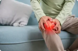 Person holding a painful knee from osteoarthritis.